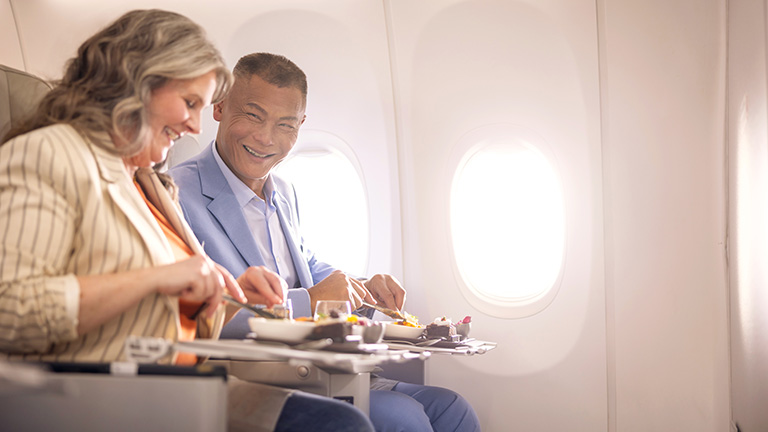 Man and woman eating on the plane